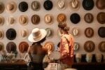 A stylish couple exploring a hat boutique, showcasing diverse headwear.